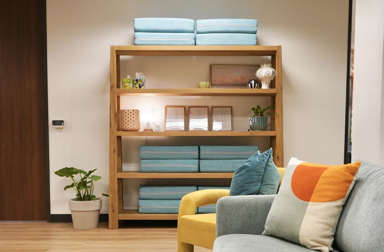 Yoga bolsters on open shelving beside lounge seating at Empowered Treatment in Austin